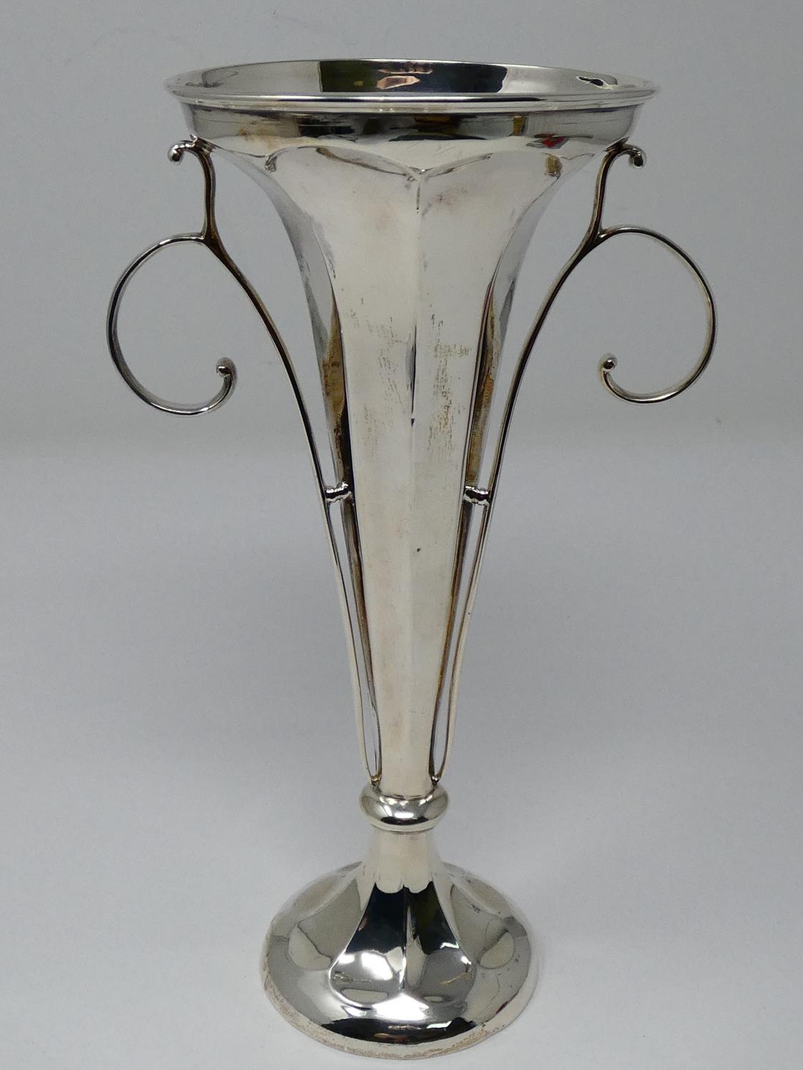 An Edwardian silver centre piece trumpet vase with weighted base, faceted design and scrolling