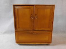 A vintage elm Ercol cabinet with panel doors and drop down base door fitted for HI Fi. H.94xW.85xL.