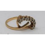 A 9ct yellow gold and diamond stylised floral design ring. Set with eight round brilliant cut