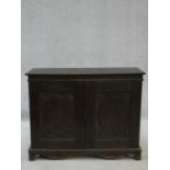 An antique country oak hall cupboard with a pair of carved panel doors on bracket feet. H.64 W.82