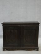 An antique country oak hall cupboard with a pair of carved panel doors on bracket feet. H.64 W.82