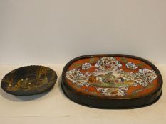 A Japanese black lacquered shallow bowl with gilt decoration showing figures in a court setting