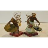 A pair of vintage cold painted cast metal monkey figures each carrying a trumpet shape glass spill