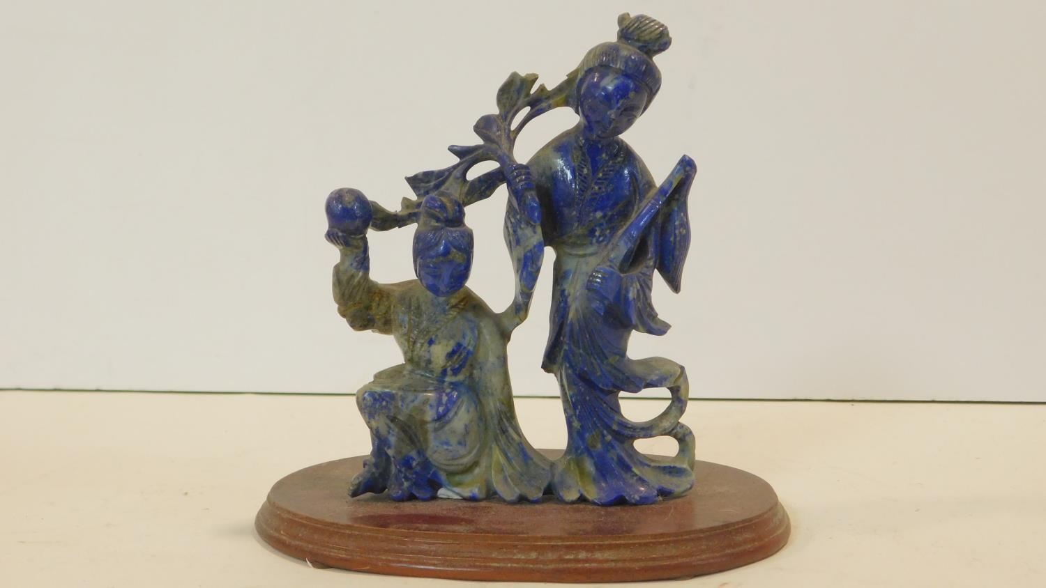 A Chinese lapis lazuli carved figure group, two figures performing a ceremonial dance on oval oak