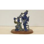 A Chinese lapis lazuli carved figure group, two figures performing a ceremonial dance on oval oak