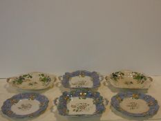 A collection of antique printed and hand colored floral design plates. Two with handles. The other