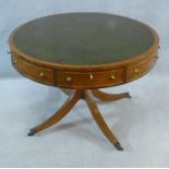A Regency style yew wood drum table with inset leather top above four frieze drawers raised on