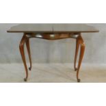 A 19th century French walnut serpentine fronted tea table with foldover swivel action raised on
