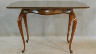 A 19th century French walnut serpentine fronted tea table with foldover swivel action raised on