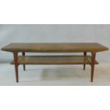 A 1970's vintage teak coffee table on tapering supports united by caned undertier. H.47 W.137 D.46cm