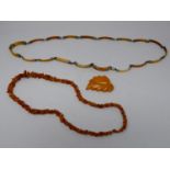 A collection of amber and ivory jewellery. Including an amber leaf brooch, a graduated amber chip