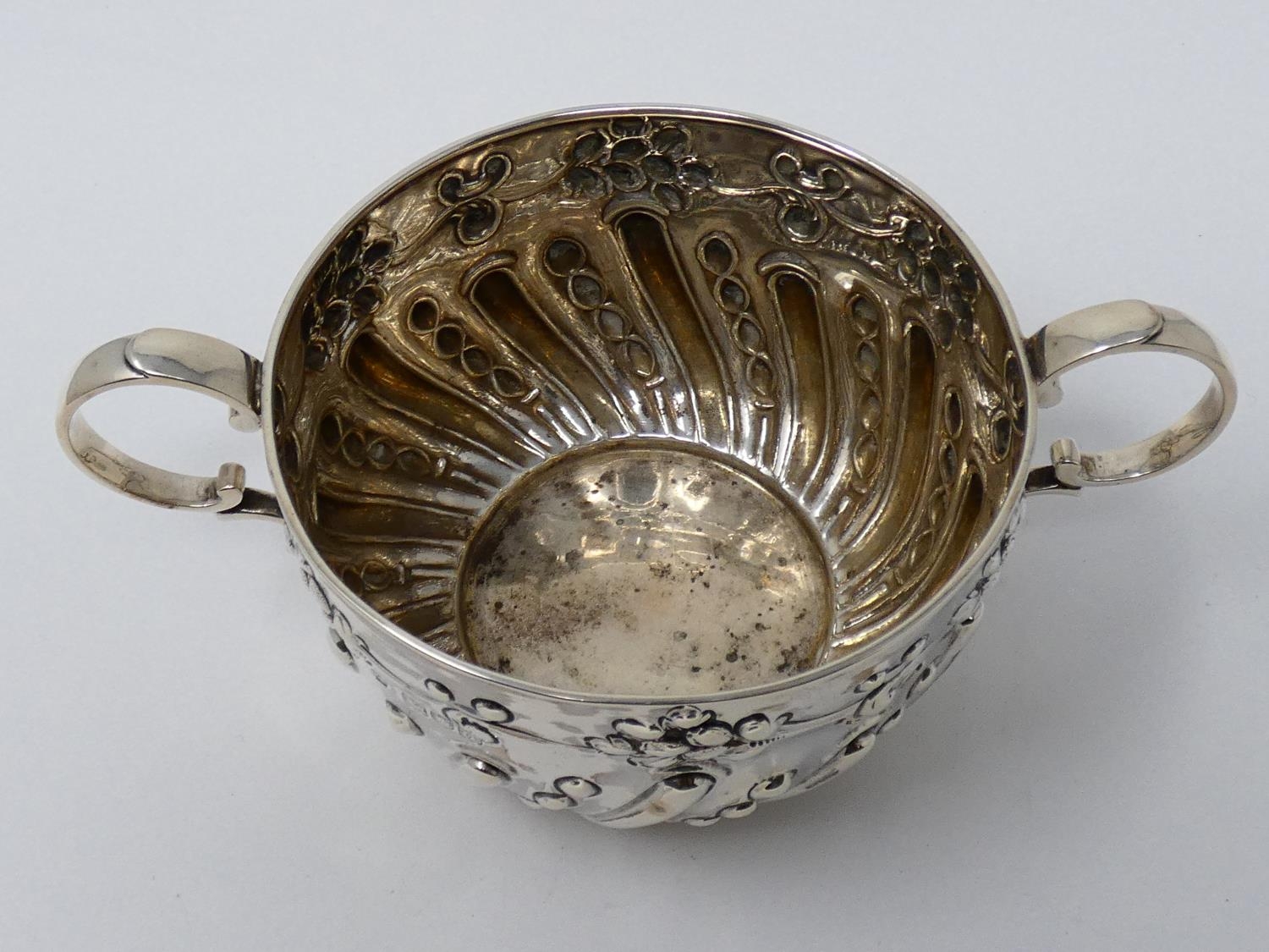 A two handled Victorian repousse design silver porriger with floral design and scrolling handles. - Image 3 of 6