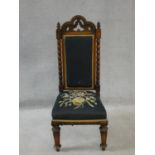 A late Victorian walnut Gothic carved prie dieu style side chair in floral tapestry upholstery. H.