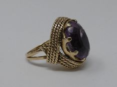 A 9 ct carat yellow gold and amethyst dress ring. Set with an oval mixed cut amethyst in an eight