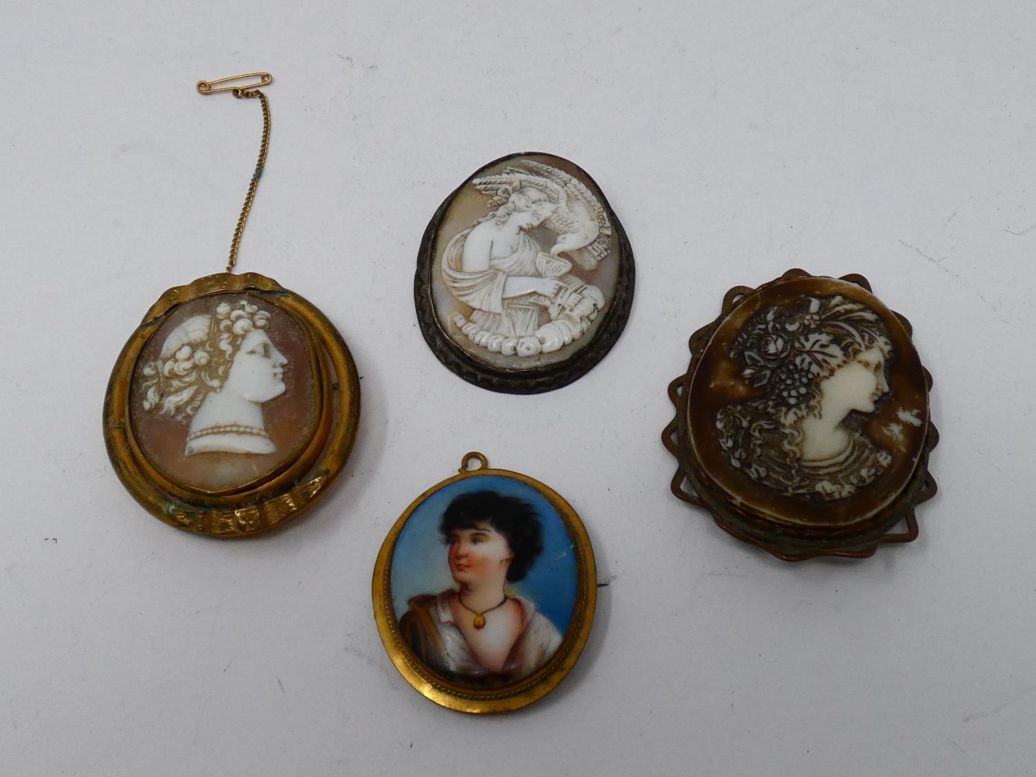 A collection of antique brooches and pendants. Including two craved shell cameos with classical