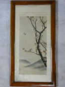 An early 20th century framed and glazed Japanese silk embroidery, a bird in flight with blossom on