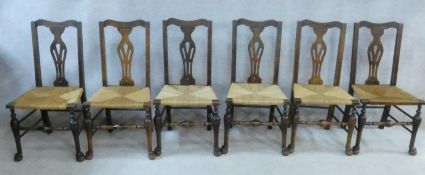 A set of six 19th century country oak dining chairs with pierced splat backs above woven rush