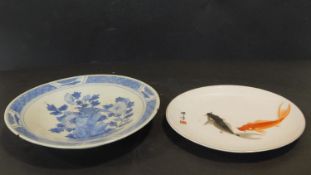 Two antique hand painted Oriental ceramic plates. One with a blue and white floral design with a