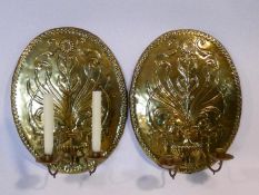 A pair of 18th century repousse design oval brass wall sconces, with stylised floral and foliate