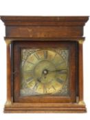A Georgian oak cased clock with black Roman numerals on a brass dial within applied spandrels and