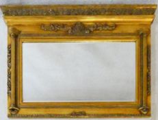 A Regency style gilt framed overmantel mirror with architectural pediment above bevelled plate