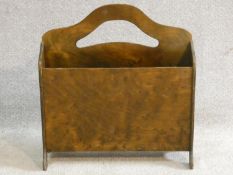 A mid century vintage laminated ply wood two section magazine basket with pierced cut carrying