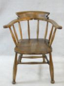 A 19th century spindle back captain's armchair with elm seat on turned stretchered supports. H.82cm