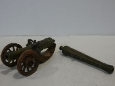 A 19th century brass desk signal cannon mounted on carved carriage along with a brass cannon barrel.