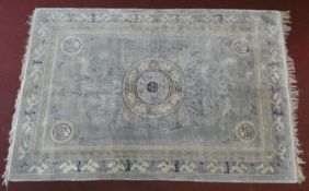 A Chinese carpet with central floral medallion on pale ground contained by spandrels decorated