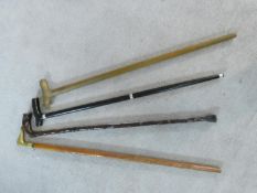 A collection of four various carved and brass handled walking sticks. H.92cm
