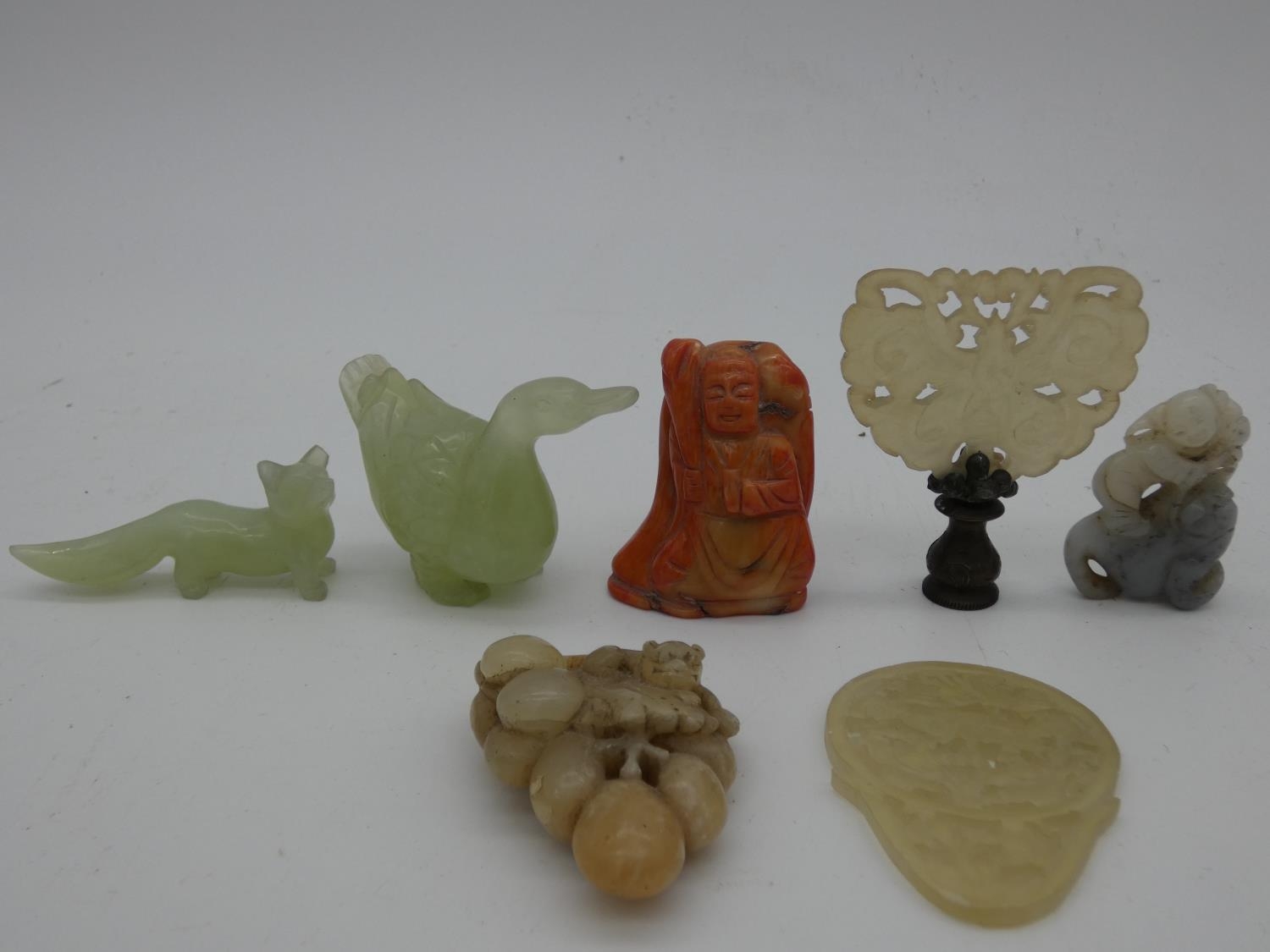 A miscellaneous collection of seven Chinese carvings in jade and coral, including figures,