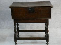 An 18th century country oak bible box with hinged lidded top and metal lock and clasp on stand