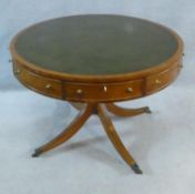 A Regency style yew wood drum table with inset leather top above four frieze drawers raised on