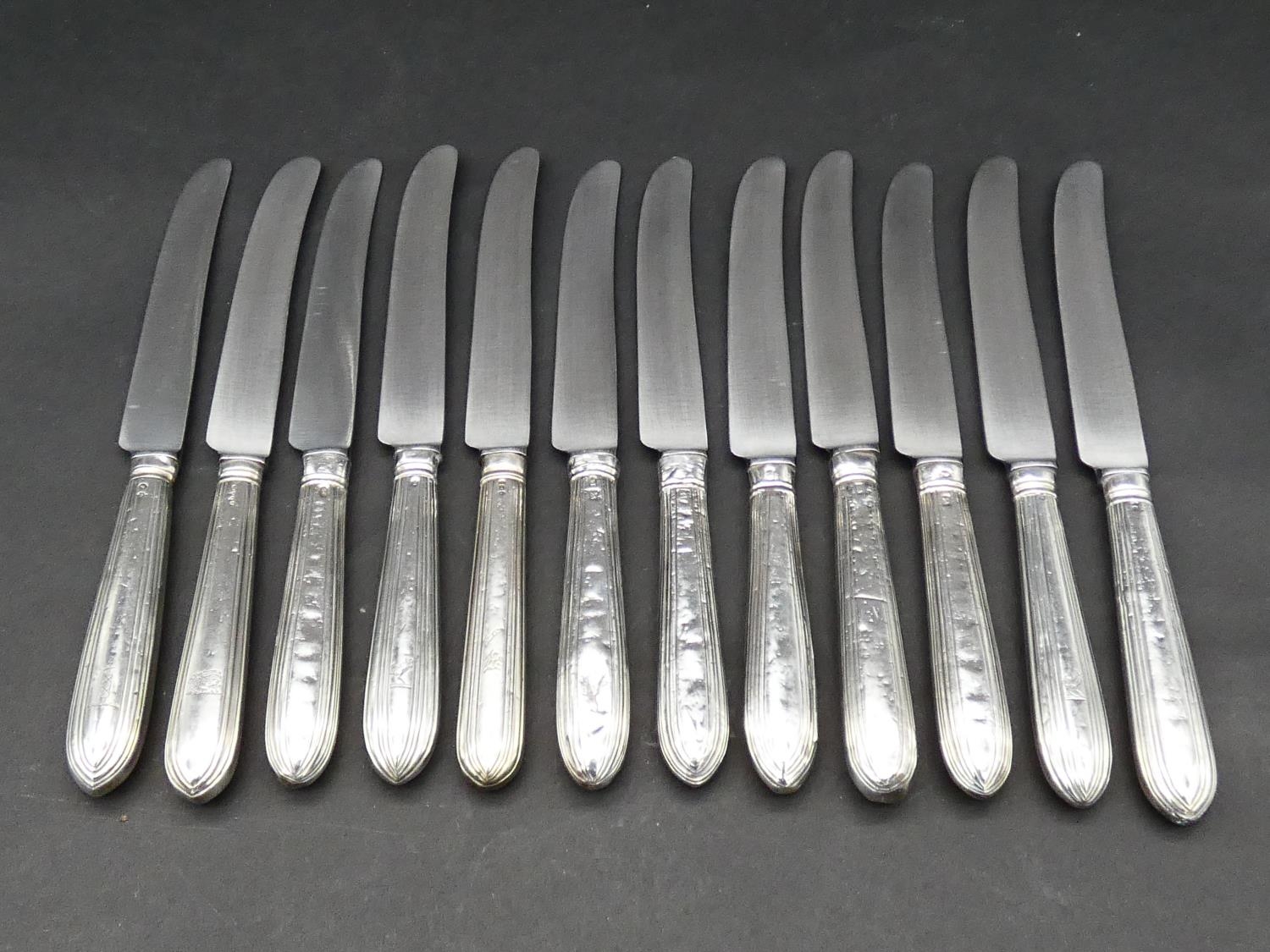 A set of twelve silver handled table knives by Robert Tricket, Moses Brent, John Carter II and