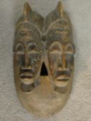 A carved hardwood Baule 'Twin Face Mask' from the Ivory Coast 37x20cm