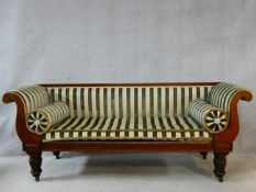 A mid 19th century mahogany framed sofa in Regency striped velour upholstery with a long fitted