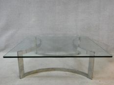 A vintage low table in the style of Gavina, the heavy plate glass top resting on a shaped chrome