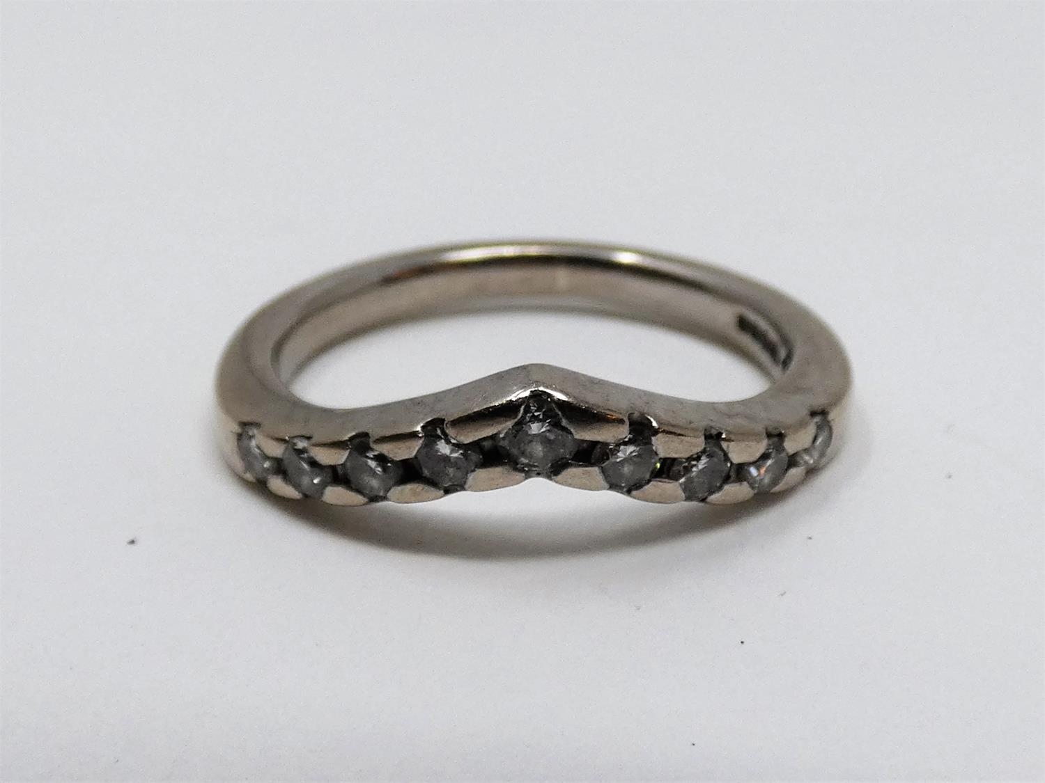 A vintage wishbone 18ct white gold and diamond half eternity ring. Set with nine round brilliant cut