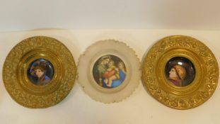 A pair of Continental brass chargers with hand painted central portraits on porcelain panels along