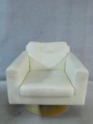 A vintage style revolving armchair in cream leather upholstery on circular laminated base. H.68 W.74