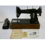 A vintage cased sewing machine with maker's and retailer's labels and with original papers and