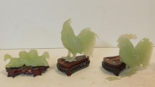 A Chinese carved jade figure of a pair of dogs on carved and pierced hardwood base and two similar