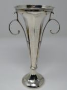 An Edwardian silver centre piece trumpet vase with weighted base, faceted design and scrolling