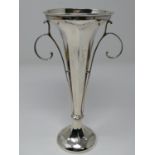 An Edwardian silver centre piece trumpet vase with weighted base, faceted design and scrolling