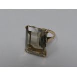 A 9ct yellow gold and citrine dress ring. Set with a rectangular mixed cut pale yellow stone in a