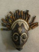 A carved and painted Chokwe Mwano Pwo face mask with tassled headdress, from Angola. 31x18cm