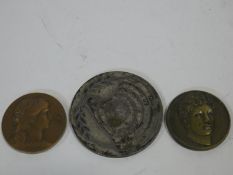 Three commemorative medals, one copper, one white metal and one brass, each with a relief design