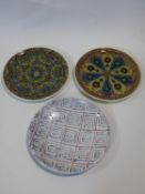 Two Islamic glazed plates and a terracotta Art Pottery charger, each hand decorated. D.33cm