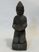 A carved reconstituted stone statue of a kneeling Buddha. H.45xW.15xL.18cm