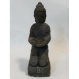 A carved reconstituted stone statue of a kneeling Buddha. H.45xW.15xL.18cm